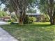 A home with meticulously maintained lawn and beautiful landscaping, complemented by mature trees that frame the architecture at 1634 Hull Cir, Orlando, FL 32806