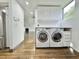 Modern laundry room with white washer and dryer and adjacent living area at 1634 Hull Cir, Orlando, FL 32806