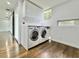 Modern laundry room with white washer and dryer, cabinets, and hardwood floors at 1634 Hull Cir, Orlando, FL 32806