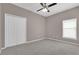 Carpeted bedroom with a window, double closet, and ceiling fan at 1730 Ribbon Falls Pkwy, Orlando, FL 32824