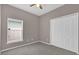 Carpeted bedroom featuring a window with blinds and double closets at 1730 Ribbon Falls Pkwy, Orlando, FL 32824