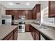 The updated kitchen features stainless steel appliances, dark wood cabinets, plenty of counter space, and modern fixtures at 1730 Ribbon Falls Pkwy, Orlando, FL 32824