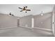 Open-concept living area with tile and carpet flooring, ceiling fans, and neutral paint, offering versatility at 1730 Ribbon Falls Pkwy, Orlando, FL 32824