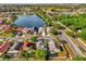 An aerial view shows waterfront homes with manicured lawns and tree-lined streets in a community at 1851 Wimbledon St, Kissimmee, FL 34743