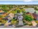 Beautiful aerial view of a well-maintained home with a lake view, lush landscaping, and a gray roof at 1851 Wimbledon St, Kissimmee, FL 34743