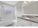 Bright bathroom featuring a tub, shower, and a granite countertop vanity with white cabinetry at 1851 Wimbledon St, Kissimmee, FL 34743