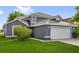 Charming gray two-story home with a well-manicured lawn and a two-car garage at 1851 Wimbledon St, Kissimmee, FL 34743