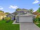Inviting gray two-story home with a lush green lawn and a two-car garage at 1851 Wimbledon St, Kissimmee, FL 34743