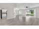 Open living room with modern wood floors, an adjacent kitchen, and sliding doors to the outside at 1851 Wimbledon St, Kissimmee, FL 34743