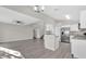Spacious living room with wood floors, a staircase, and an adjacent modern kitchen at 1851 Wimbledon St, Kissimmee, FL 34743