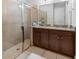 Bathroom with dual sinks, granite countertops, and a glass-enclosed shower at 193 Captiva Dr, Davenport, FL 33896