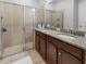 Bathroom featuring granite counters, double sinks, and a glass-enclosed shower at 193 Captiva Dr, Davenport, FL 33896