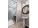 Stylish bathroom featuring a pedestal sink, decorative mirror, and walk-in shower at 193 Captiva Dr, Davenport, FL 33896