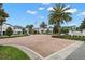 Well-maintained community entrance with brick-paved road and attractive landscaping under a partly cloudy sky at 193 Captiva Dr, Davenport, FL 33896
