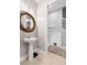 Cozy powder room features a pedestal sink, decorative mirror, and neutral decor at 193 Captiva Dr, Davenport, FL 33896