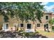 Backyard of the home with a tree shading the back windows, sliding glass doors, and grass at 207 Sterling Springs Ln, Altamonte Springs, FL 32714