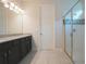 Modern bathroom with granite counters, dual sinks, and a glass-enclosed shower for a spa-like experience at 2168 Marsh Sedge Ln, Winter Park, FL 32792