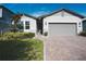 Charming single-story home with a manicured lawn, brick driveway, and two-car garage at 2168 Marsh Sedge Ln, Winter Park, FL 32792