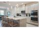 Modern kitchen with white cabinets, stainless steel appliances, and an island with bar seating at 2168 Marsh Sedge Ln, Winter Park, FL 32792