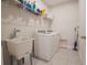 Laundry room includes washer, dryer, utility sink, and shelving for storage at 2168 Marsh Sedge Ln, Winter Park, FL 32792