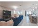 Spacious living room featuring a plush blue sofa, contemporary lighting, and an open layout at 2168 Marsh Sedge Ln, Winter Park, FL 32792