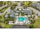 Aerial view of a community pool with ample seating and surrounding palm trees and buildings at 2168 Marsh Sedge Ln, Winter Park, FL 32792