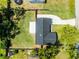 Aerial view of home featuring a dark roof, deck, driveway and partially fenced yard at 2412 Yule Tree Dr, Edgewater, FL 32141