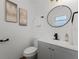 Bright bathroom featuring modern vanity, round mirror, and neutral wall art at 2412 Yule Tree Dr, Edgewater, FL 32141