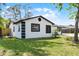 Side view of a charming home featuring a well-manicured lawn and a well-maintained exterior, nestled amongst mature trees at 2412 Yule Tree Dr, Edgewater, FL 32141