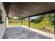 Covered patio area overlooking a spacious, fenced backyard with green grass at 2412 Yule Tree Dr, Edgewater, FL 32141