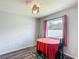 Cozy dining area with wood floors, table with red tablecloth, and a window with pink curtains at 284 Talladega Ln, Polk City, FL 33868