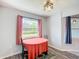Dining area featuring wood floors, a window with black and pink curtains, and decorative lighting at 284 Talladega Ln, Polk City, FL 33868
