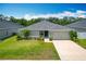Well-maintained single-story home featuring a lush green lawn and a two car garage at 284 Talladega Ln, Polk City, FL 33868