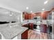 Modern kitchen featuring stainless steel appliances, granite countertops, and wood-style flooring at 284 Talladega Ln, Polk City, FL 33868