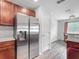 Kitchen with stainless steel refrigerator, granite countertops, and dark wood cabinets at 284 Talladega Ln, Polk City, FL 33868