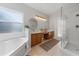 Bathroom featuring double sinks, tiled floors, and a separate tub and glass-enclosed shower at 2889 Blooming Alamanda Loop, Kissimmee, FL 34747