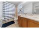 Bathroom with double sinks, wood cabinets, a bathtub with shower, and blue and white accents at 2889 Blooming Alamanda Loop, Kissimmee, FL 34747