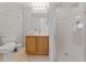 Well-lit bathroom with a modern vanity, walk-in shower with glass door and tiled walls at 2889 Blooming Alamanda Loop, Kissimmee, FL 34747