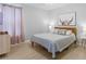 Bedroom features hardwood floors, a queen bed, gray bedding, and natural light from the window at 2889 Blooming Alamanda Loop, Kissimmee, FL 34747