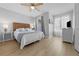 Bedroom with a woven headboard, a queen bed, wood floors, and natural light from the window at 2889 Blooming Alamanda Loop, Kissimmee, FL 34747