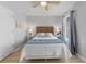 Bedroom with a woven headboard, a queen bed, wood floors, and natural light from the window at 2889 Blooming Alamanda Loop, Kissimmee, FL 34747