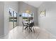 Bright breakfast nook features gray chairs, modern light fixture, and sliding glass doors to the outdoor pool at 2889 Blooming Alamanda Loop, Kissimmee, FL 34747