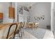 Spacious dining room featuring a large table and modern chandelier, adjacent to the kitchen and staircase at 2889 Blooming Alamanda Loop, Kissimmee, FL 34747