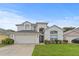 Inviting two-story home with a manicured lawn and attached two-car garage at 2889 Blooming Alamanda Loop, Kissimmee, FL 34747