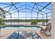 The screened-in pool features a relaxing lounge area with scenic lake views perfect for enjoyment at 2889 Blooming Alamanda Loop, Kissimmee, FL 34747