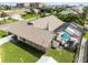 Aerial view of home featuring a pool, screened lanai, beautiful landscaping, and green backyard at 30 Capistrano Dr, Ormond Beach, FL 32176