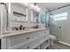 Bathroom featuring double vanity, shiplap accent wall, and tiled glass shower at 30 Capistrano Dr, Ormond Beach, FL 32176