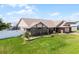 Charming single-story brick home featuring a manicured lawn, water feature, and a white picket fence at 30 Capistrano Dr, Ormond Beach, FL 32176