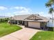 Beautiful single-story brick home with an attached garage, red brick driveway, and manicured landscaping at 30 Capistrano Dr, Ormond Beach, FL 32176
