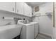 Practical laundry room featuring utility sink, appliances, and ample storage space at 30 Capistrano Dr, Ormond Beach, FL 32176